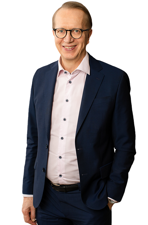 Janne Metsämäki katso kameraan tumma puku päällään ja hymyilee.